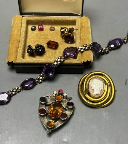 A white metal and gem set shield brooch, 49mm, a white metal and amethyst set necklace and other minor jewellery including unmounted pink sapphire and citrine.